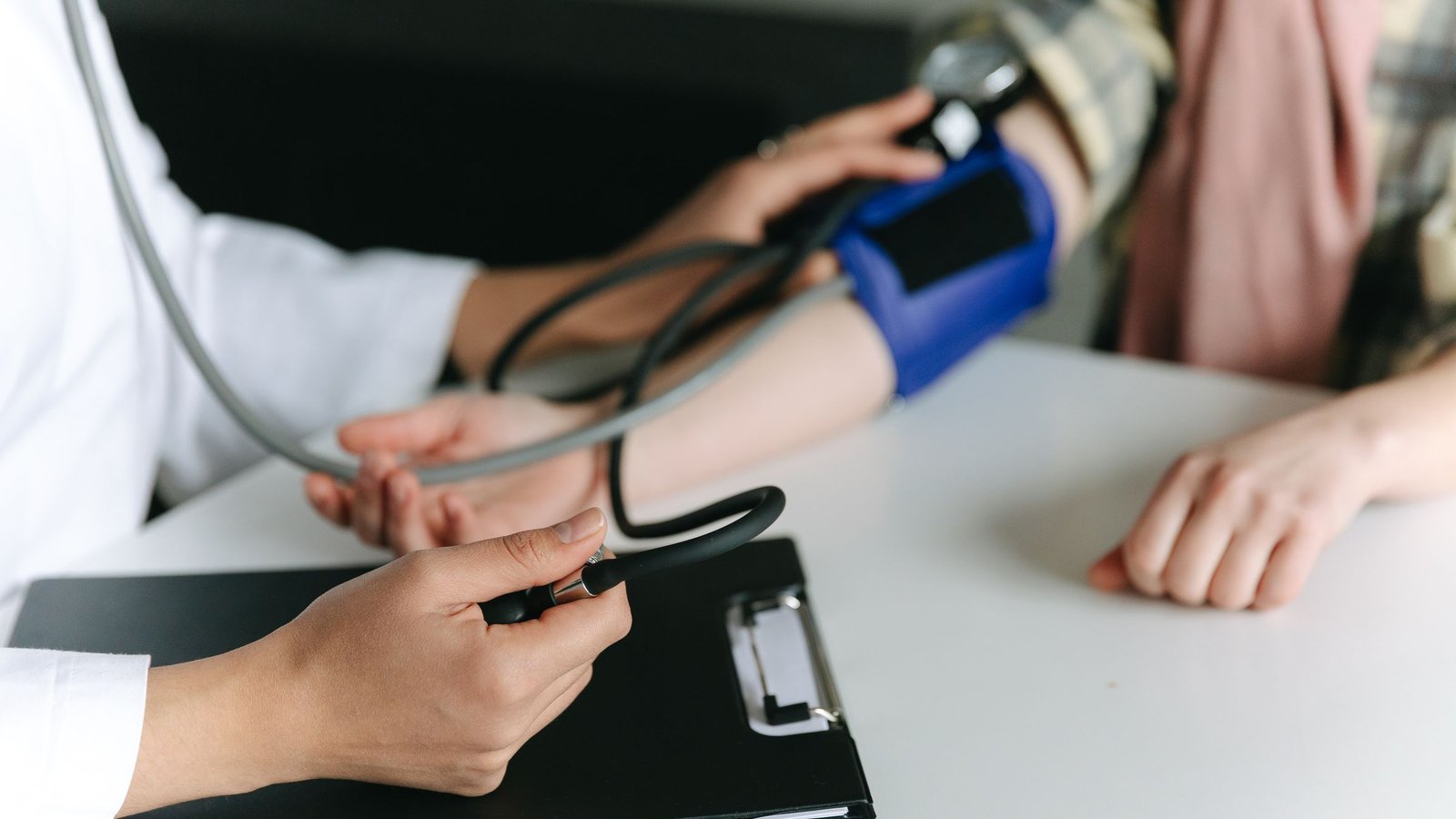 A health worker measuring a patient’s blood pressure